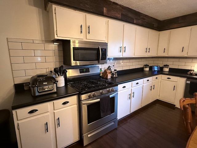 108 Melcher Blvd, Bucyrus, OH 44820 - kitchen with stainless steel appliances, dark countertops, white cabinetry, dark wood-type flooring, and a textured ceiling