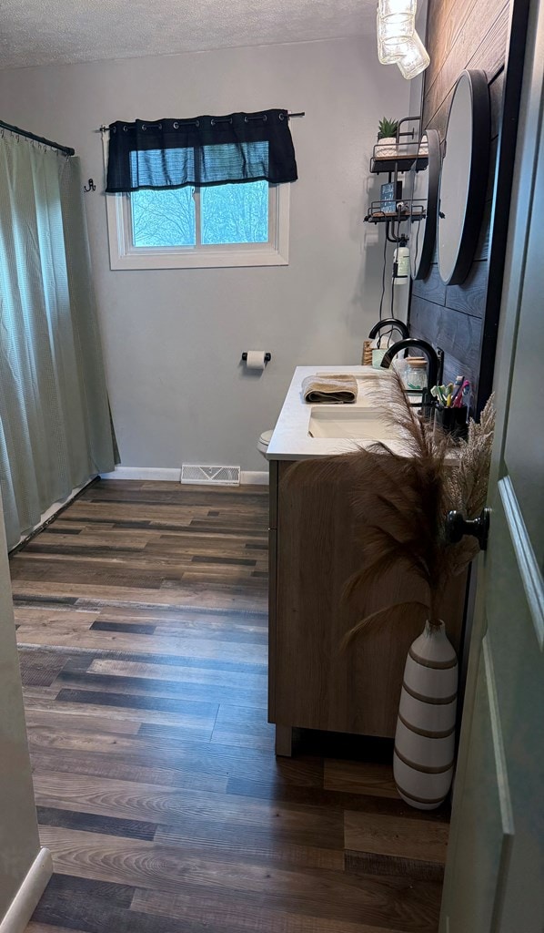 108 Melcher Blvd, Bucyrus, OH 44820 - bathroom featuring vanity, wood finished floors, a textured ceiling, a shower with curtain, and baseboards