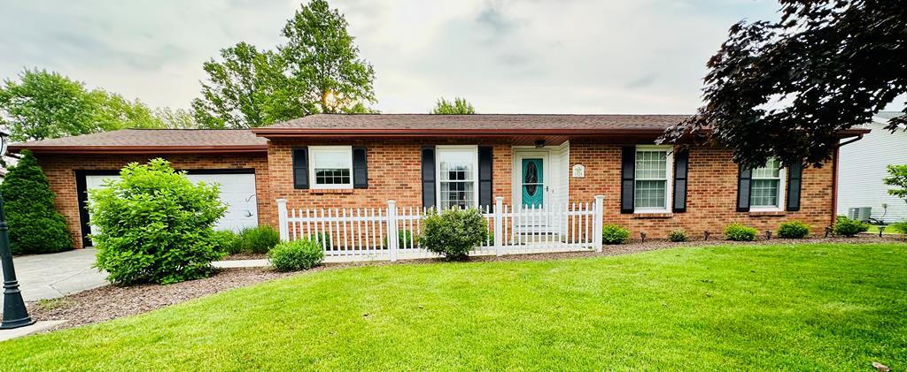 1124 Farmview Dr, Bucyrus, OH 44820 - ranch-style house with brick siding, a garage, a front yard, and driveway
