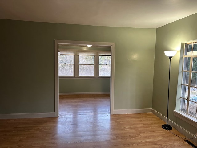 unfurnished room featuring light wood-type flooring and baseboards