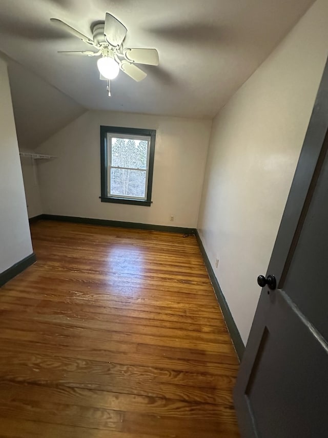 additional living space with wood finished floors, lofted ceiling, baseboards, and ceiling fan