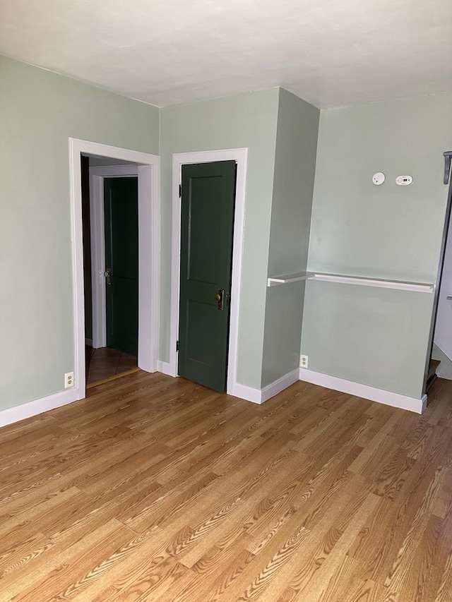 empty room featuring baseboards and light wood-style floors