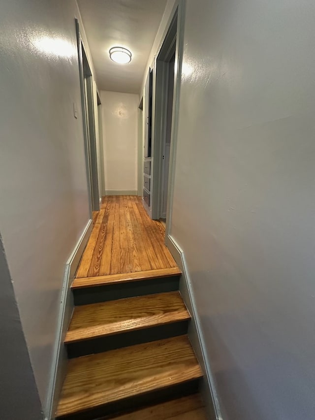 stairway featuring wood finished floors and baseboards