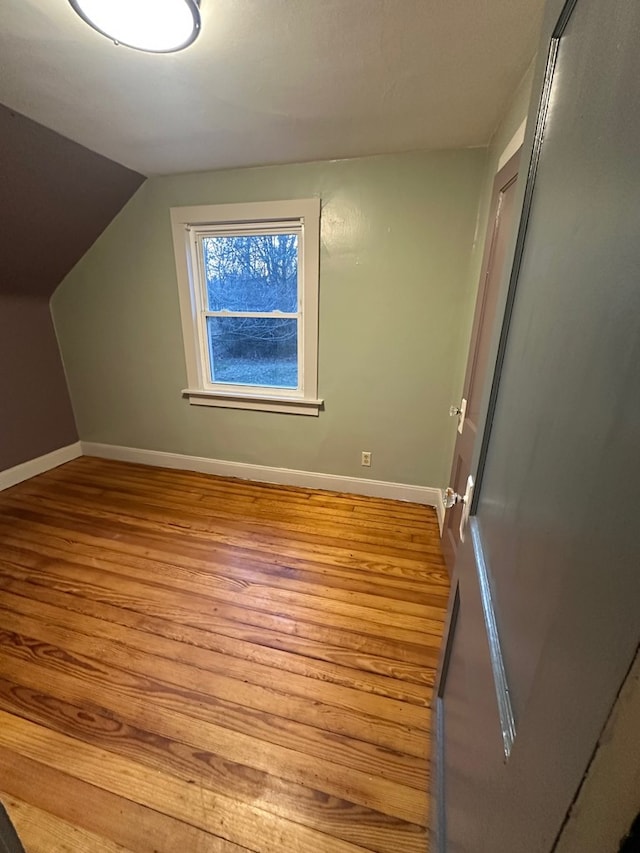 bonus room with wood finished floors, lofted ceiling, and baseboards