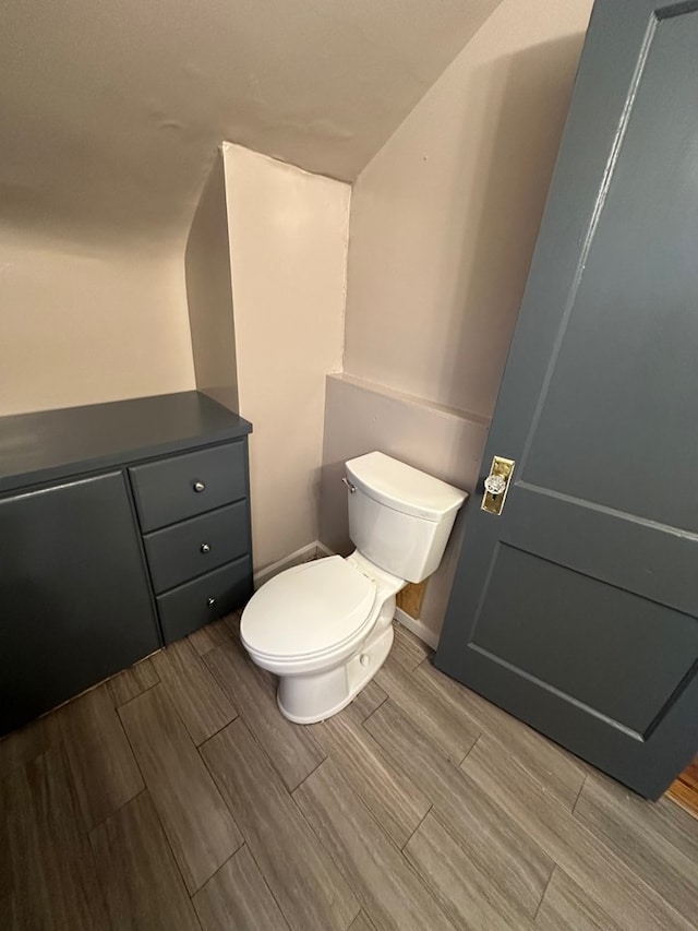 half bath featuring wood tiled floor and toilet