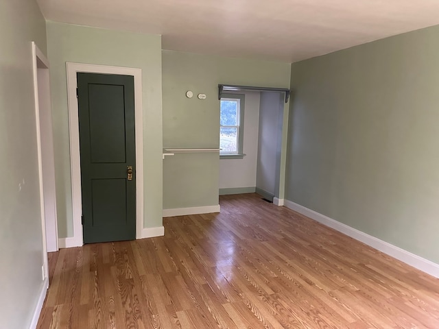 unfurnished room featuring baseboards and wood finished floors