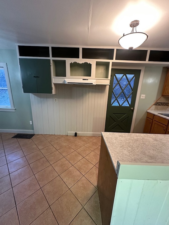 kitchen with open shelves, baseboards, and light tile patterned floors