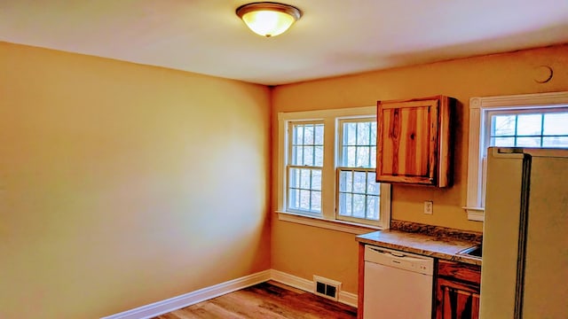 kitchen with dark countertops, visible vents, a healthy amount of sunlight, and dishwasher