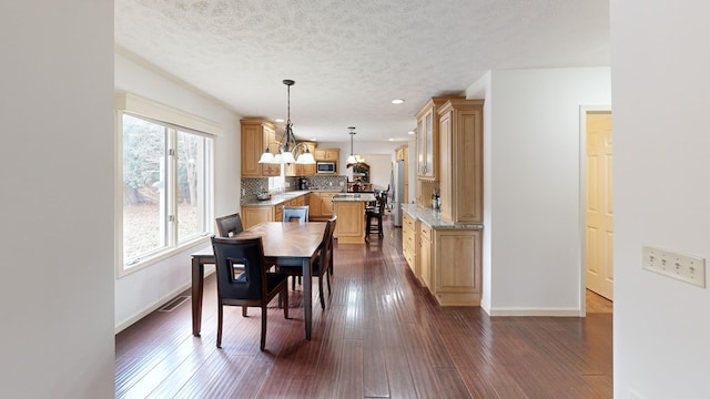 dining space featuring dark hardwood / wood-style floors and a textured ceiling