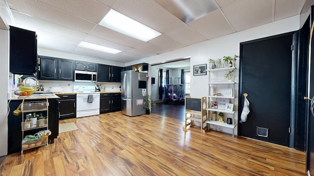 41 Auburn Ave, Shelby, OH 44875 - kitchen with white appliances, light countertops, dark cabinets, a drop ceiling, and light wood-type flooring