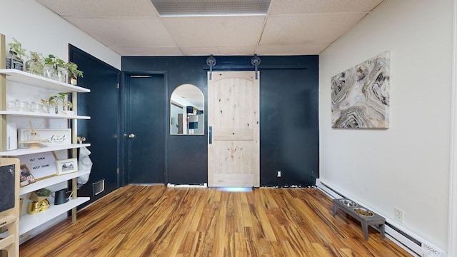 41 Auburn Ave, Shelby, OH 44875 - unfurnished bedroom with a drop ceiling, a baseboard heating unit, and wood finished floors
