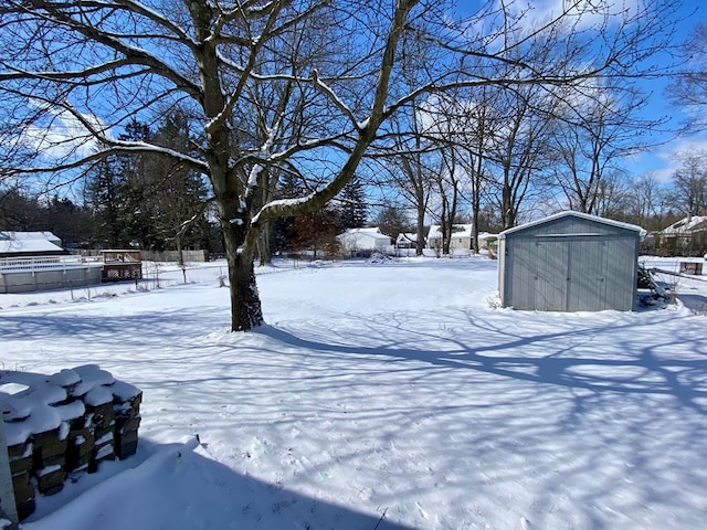 yard covered in snow featuring a storage unit