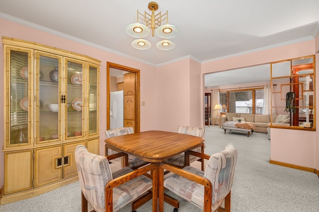 carpeted dining area featuring an inviting chandelier and crown molding