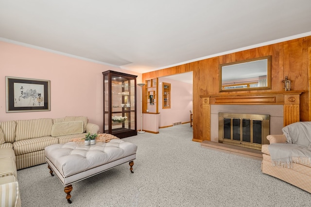 carpeted living room with wooden walls and ornamental molding