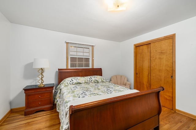 bedroom with light hardwood / wood-style floors and a closet