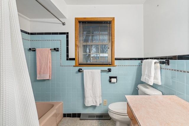 full bathroom featuring shower / bath combo, toilet, tile walls, and vanity