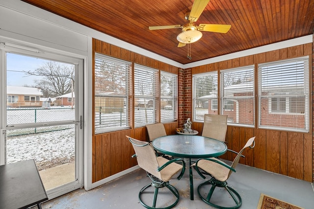 sunroom with ceiling fan, a healthy amount of sunlight, and wooden ceiling