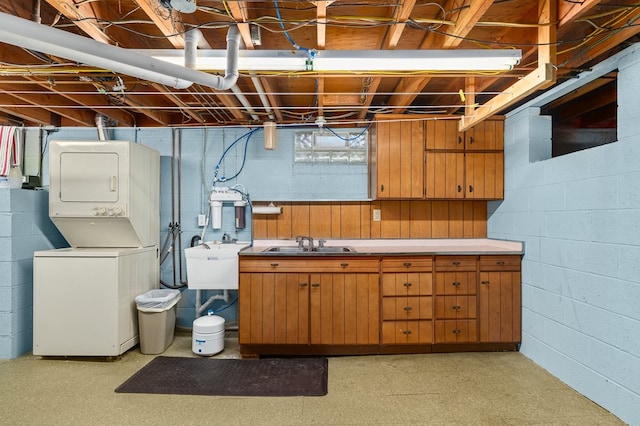 basement featuring sink and stacked washer and dryer