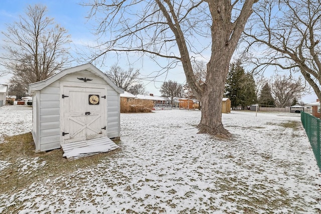 snowy yard with a storage shed