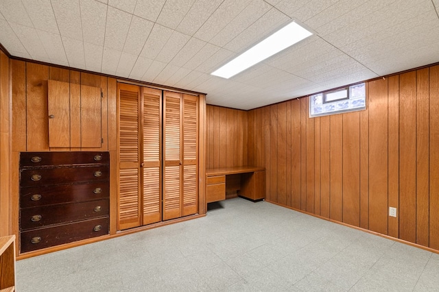 unfurnished bedroom with wood walls and a closet