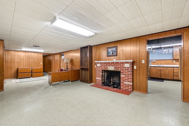 living room with wooden walls and a brick fireplace