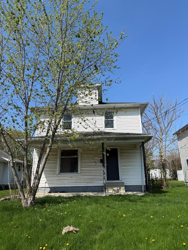 american foursquare style home featuring a porch and a front lawn