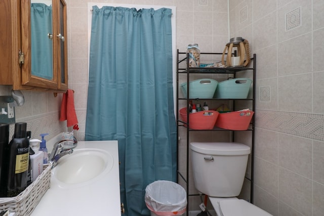 bathroom featuring a shower with curtain, toilet, vanity, and tile walls