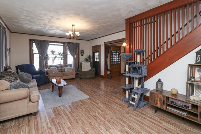 living room with stairs, ornamental molding, a chandelier, a textured ceiling, and wood finished floors