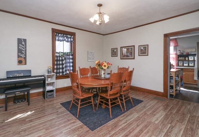 dining room featuring baseboards, crown molding, light wood-style flooring, and a chandelier
