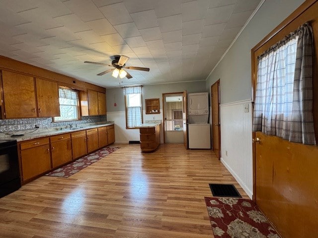 3649 Nazor Rd, Crestline, OH 44827 - kitchen featuring brown cabinetry, ceiling fan, light countertops, crown molding, and light wood-style floors