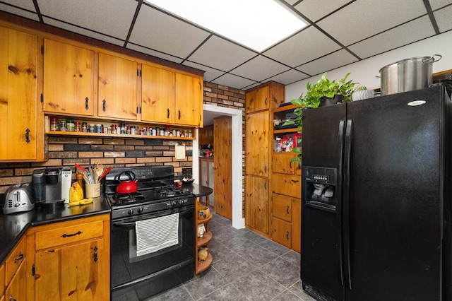 kitchen with a drop ceiling and black appliances