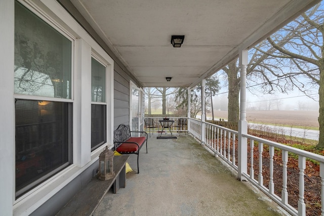 view of patio with covered porch and a rural view