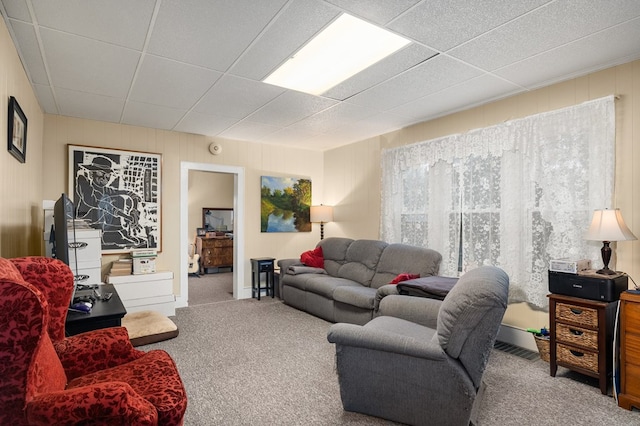 living room with carpet flooring and a paneled ceiling