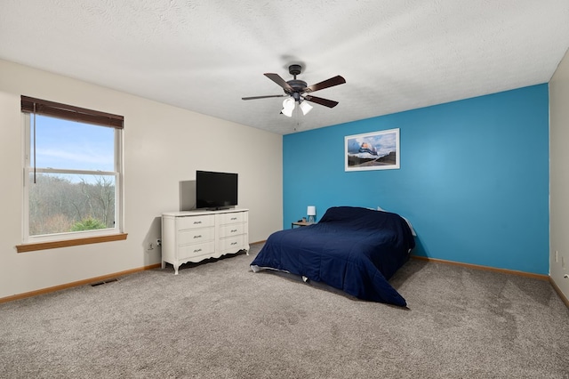 carpeted bedroom featuring a textured ceiling and ceiling fan