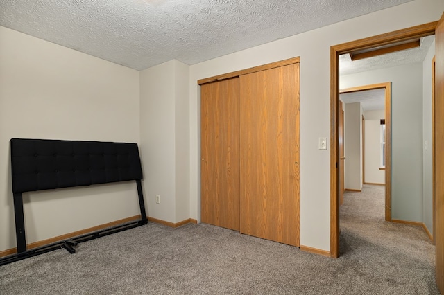 bedroom featuring light carpet, a textured ceiling, and a closet