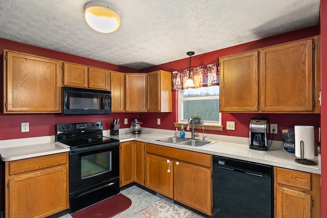 kitchen featuring pendant lighting, sink, a textured ceiling, and black appliances