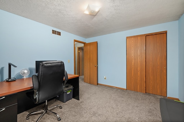 carpeted office space featuring a textured ceiling