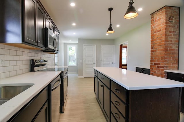 kitchen featuring a kitchen island, pendant lighting, light countertops, decorative backsplash, and stainless steel appliances