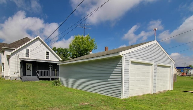 view of side of home featuring a porch, an outdoor structure, a yard, and a garage