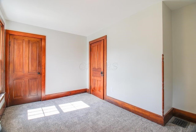 unfurnished bedroom featuring visible vents, carpet flooring, and baseboards