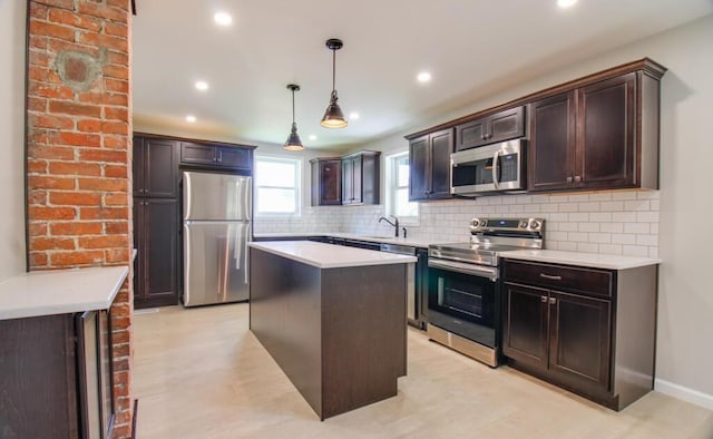 kitchen featuring a sink, stainless steel appliances, dark brown cabinets, decorative light fixtures, and tasteful backsplash