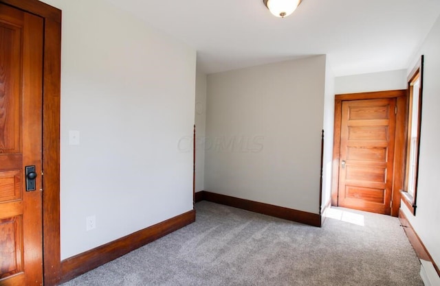 carpeted spare room featuring baseboards