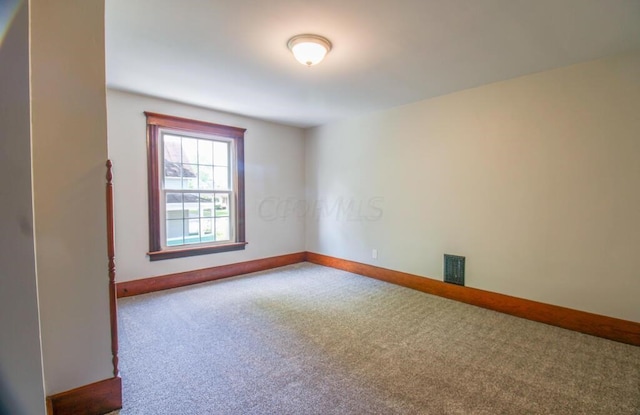 carpeted empty room with visible vents and baseboards