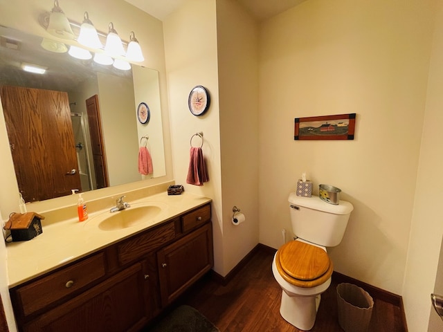 bathroom featuring hardwood / wood-style floors, vanity, toilet, and walk in shower