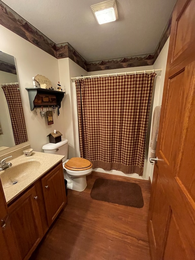 bathroom featuring hardwood / wood-style flooring, vanity, toilet, and walk in shower