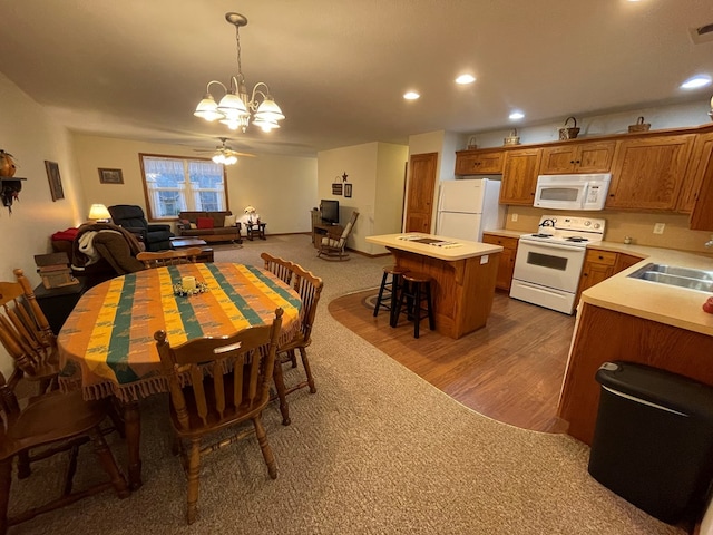 carpeted dining space with ceiling fan with notable chandelier and sink