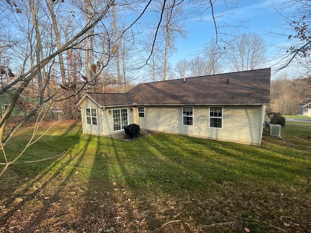 back of house featuring central AC and a yard