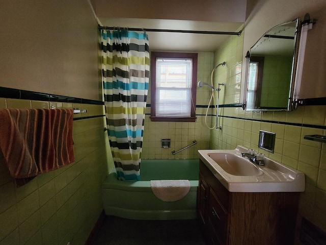 bathroom with shower / tub combo, vanity, and tile walls