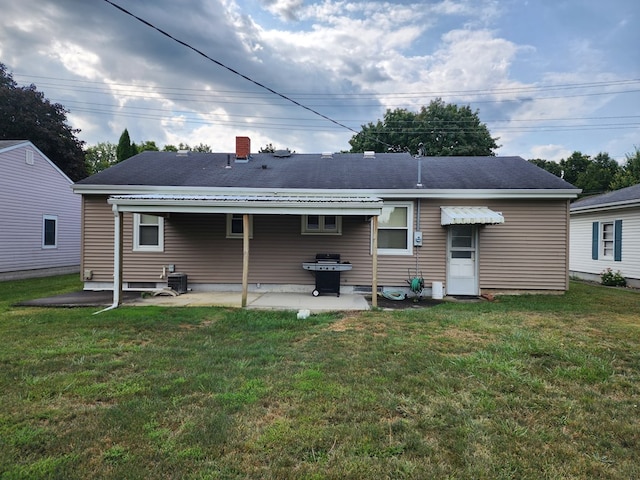 rear view of house featuring a lawn and a patio area