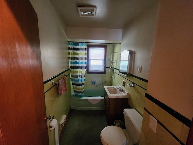 full bathroom with vanity, toilet, tile walls, and shower / bath combo with shower curtain